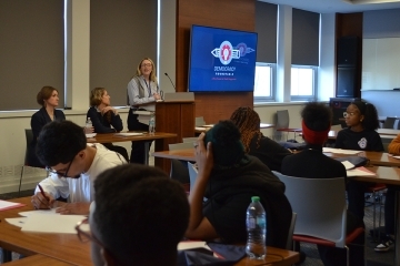 Students listening while three speakers talk