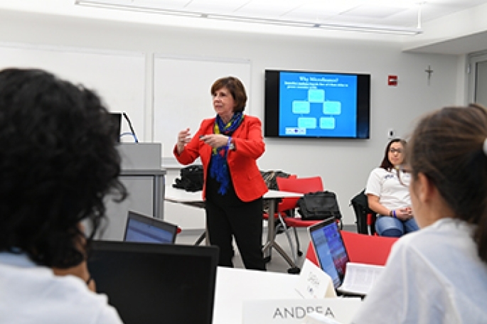 Female Faculty member teaching in room with screen