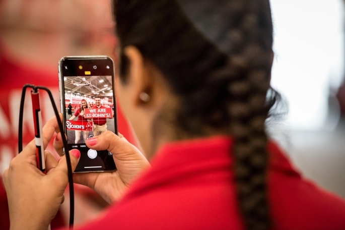 Female taking photo of group with cellphone