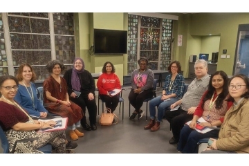 Group of faculty seated in a semi circle having a discussion