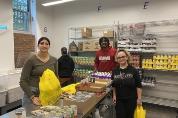 St. John's volunteers working in kitchen packaging non-perishable foods