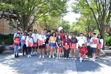 Large group of new students gathered outside at orientation