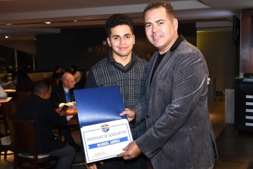 Male student holding certificate