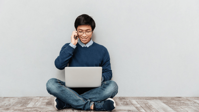 Man on phone using laptop