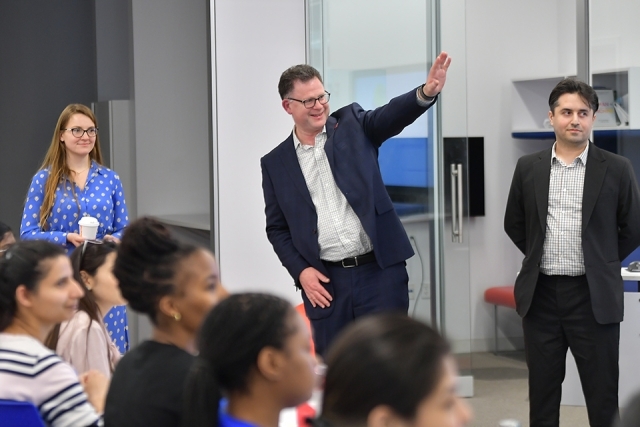 St. John's administrator waving his hand to audience at lecture