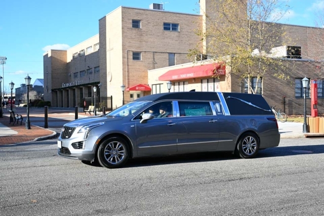 Hertz carrying Lou Carnesecca's casket entering St. John's University Campus