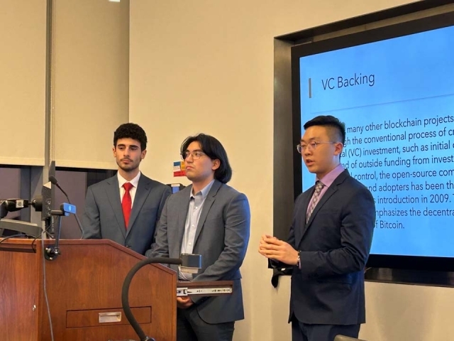 Three Tobin students speaking at podium during presentation