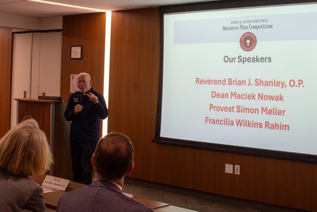 Fr. Shanley next to projector screen