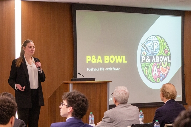 Female student presenting at James and Eileen Christmas Business Plan Competition