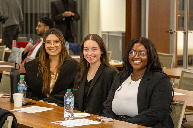 Three female students seated and smiling