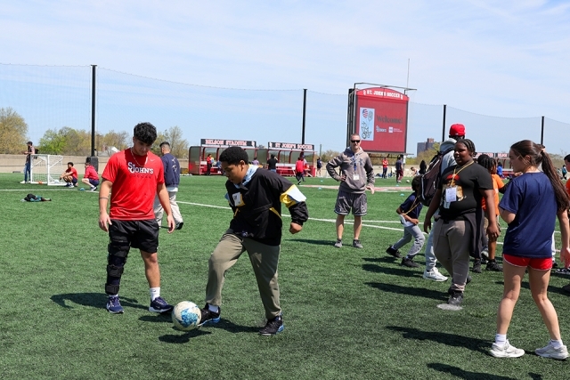 Special needs students playing soccer with St. John's athletes