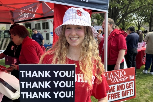St. John's student holding Thank You signs for their generous donations
