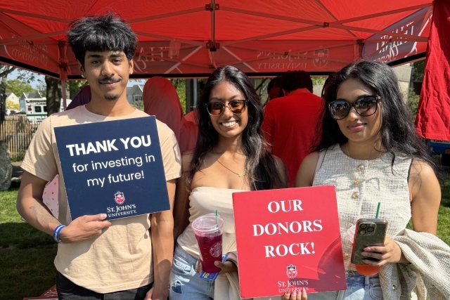St. John's student holding Thank You signs for their generous donations
