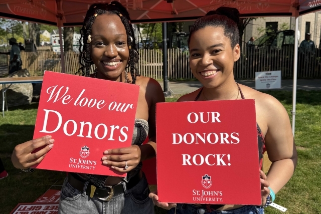 St. John's student holding Thank You signs for their generous donations