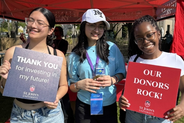 St. John's student holding Thank You signs for their generous donations