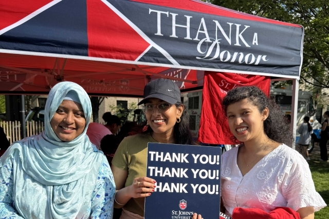 St. John's student holding Thank You signs for their generous donations