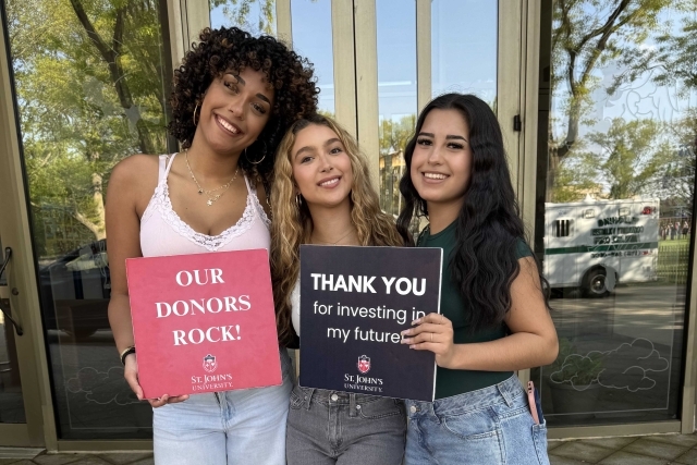 St. John's student holding Thank You signs for their generous donations