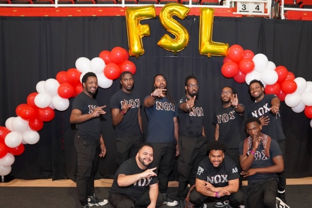 FSL in gold baloons with a red and white balloon arch and St. John's students underneath