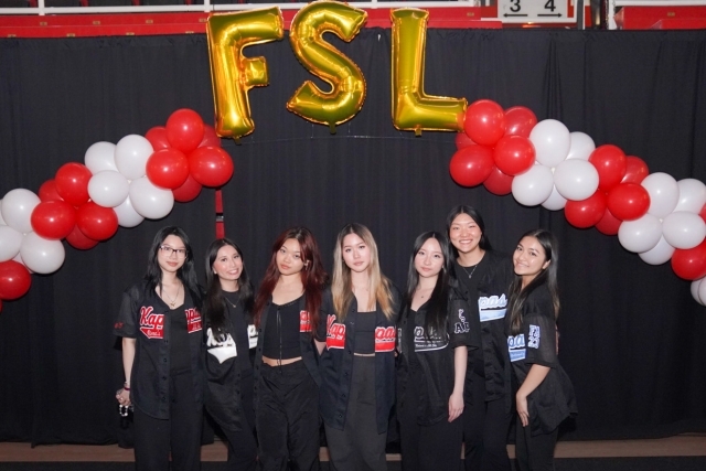 FSL in gold baloons with a red and white balloon arch and St. John's students underneath