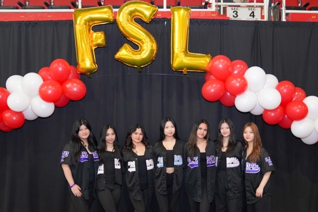 FSL in gold baloons with a red and white balloon arch and St. John's students underneath