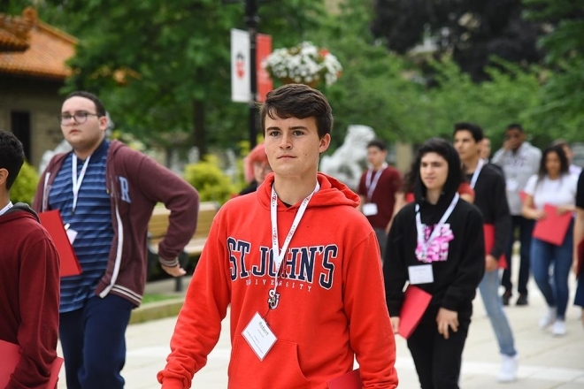 Male student walking across campus during Orientation