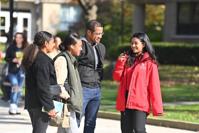 St. John's University Student Ambassador giving a campus tour to a prospective student and their family