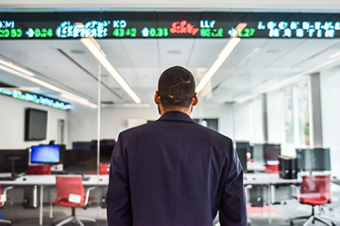 back of student who is looking at the stock ticker