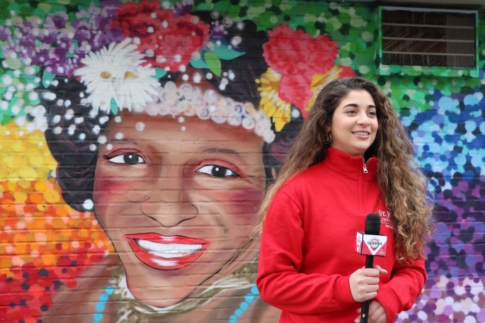 Ariana standing infront of Mural at Welling Court
