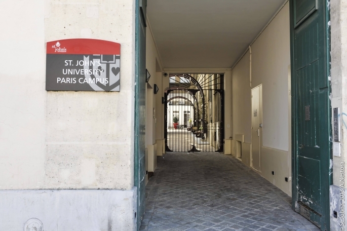 Entrance to the St. John's University Paris Campus, looking down an alley with iron gates