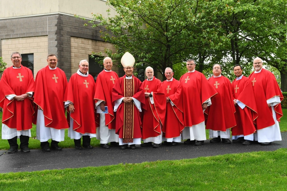 A dozen Vincentian priests standing infront of St. Thomas More Church
